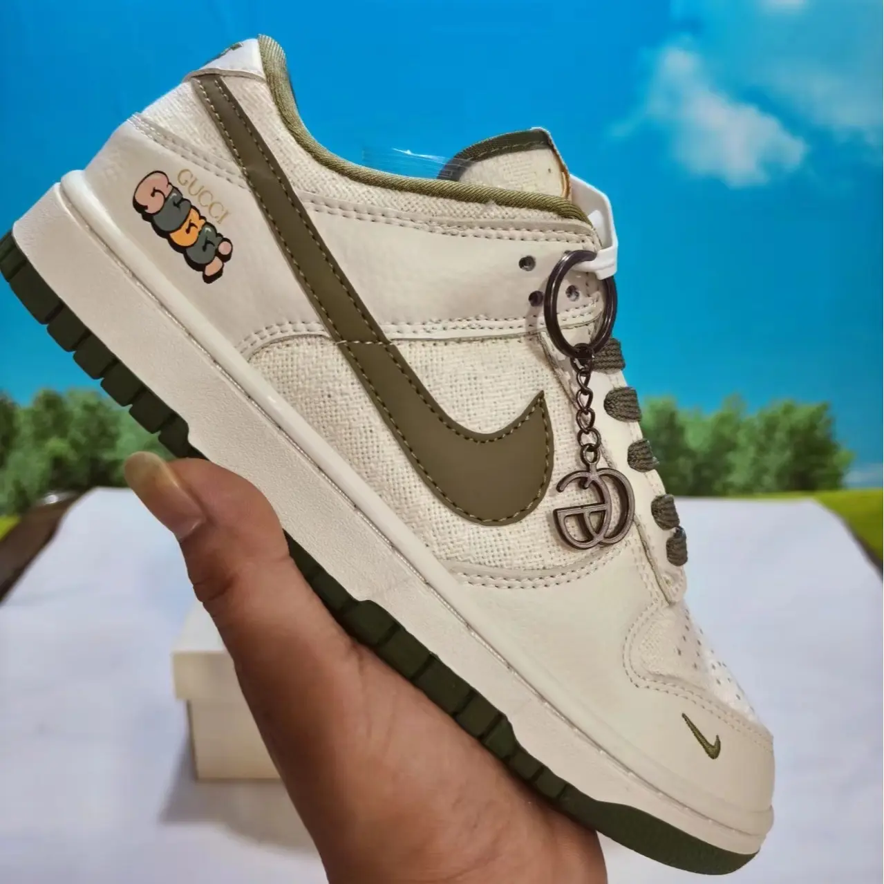 Canvas leather hybrid retro casual trainers built for versatile calm earthy all-season minimalist street fashion aesthetics, dense soft off-white woven canvas shell layered with olive green smooth leather overlays and detachable metal pendants