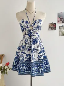 A women's halter-neck backless cutout casual dress with a blue and white floral pattern, featuring a strapless halter design. It combines vintage Chinese style with a vacation vibe, suitable for settings such as the beach or tropical holidays.