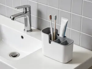 Dual-use countertop and wall organizer with divided compartments. Space-saving design in white and grey tones, neat for daily utensil storage and tidying.