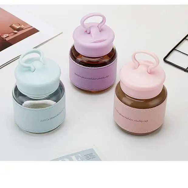 Pale mint clear glass mini water bottle, light blue silicone lid with loop handle, faux leather heat insulation sleeve, compact chubby drinking cup, portable backpack tumbler for school daily travel cold beverage