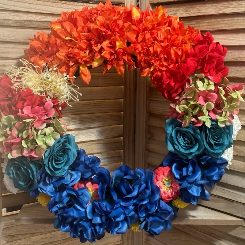 Chucky Doll Inspired Wreath with Colorful Flowers Red Orange Blue and Green Accents Decorative Design