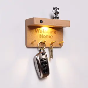 Wall-mounted key rack with hook rack and motion-sensor light; features wooden hooks, a motion-sensor light, and a key storage compartment; made of solid wood; perfect for entryways, hallways, bedrooms, and corridors