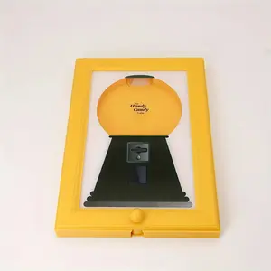 Wall-mounted square plastic picture frame with a candy, nut, or pet treat dispenser. Bright yellow-green color and no electricity required. Perfect for the kitchen, living room, child's room, or office, with its fun design and sturdy construction.