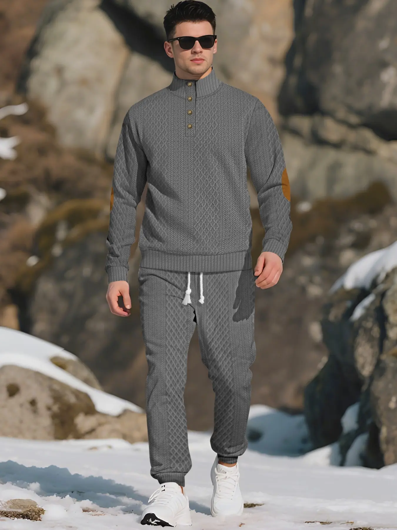 Men's knitted suit. The top features a half-placket and a high neckline, paired with simple and practical buttons. The brown elbow patches create a color contrast and match the drawstring jogger pants in the same color family. The fabric is thick.
