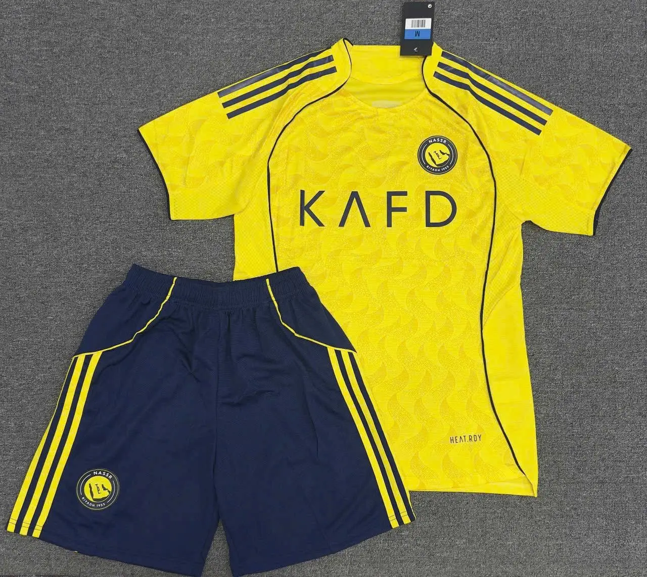 Al Nassr Yellow Soccer Jersey KAFD (Free Matching Shorts Included) Grey Carpet Flat Lay Display | Saudi Home Football Shirt | Fan Sportswear Gift