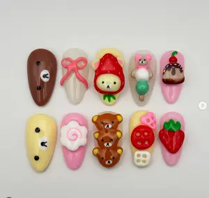 Playful and cute bear-themed nail art featuring Rilakkuma characters, strawberries, candy, and desserts in pastel pink, cream, and red tones for a sweet, kawaii vibe.