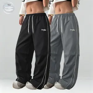 2-pack women’s lightweight summer sports pants—thin, soft, and loose fit in plus sizes. Wide-leg floor-length joggers with a casual long-pant design featuring gray side stripes paired with gold decorative trim for a comfortable athletic-casual look. Ideal