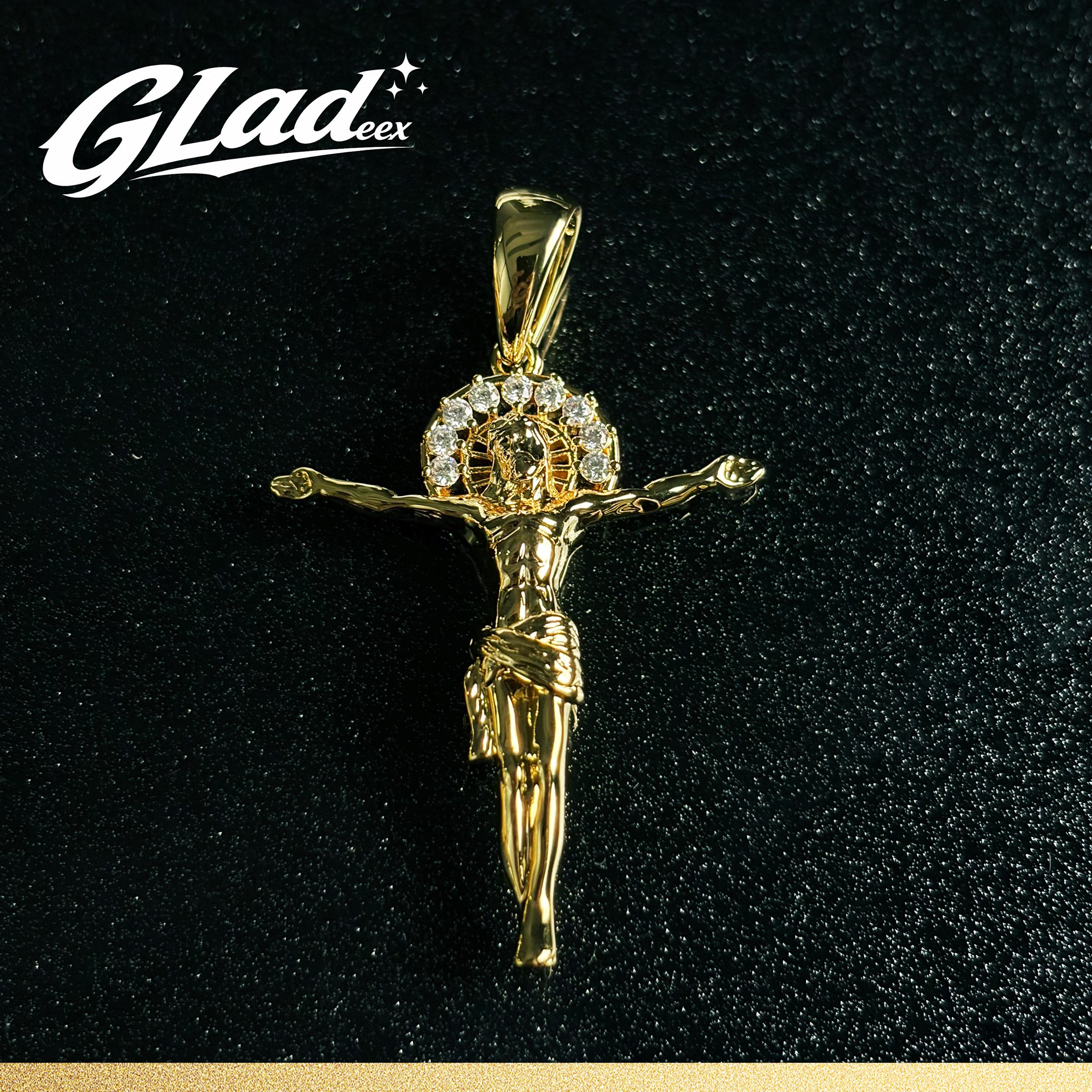 14K gold plated crucifix pendant with stone accents on a black surface