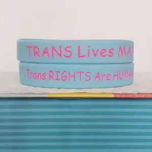 LGBTQIA+ PRIDE Silicone Wristbands saying "TRANS Lives MATTER" on one side, and "Trans RIGHTS Are HUMAN Rights" on the other side.