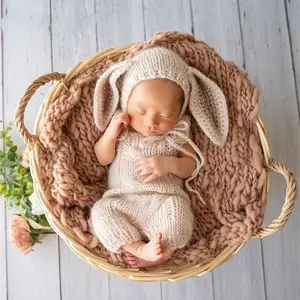 Newborn photography set featuring little rabbits. One-year-old baby outfit for autumn and winter. Clothing and styling for photography.