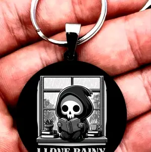 baby reaper reading book at raining day Keychain