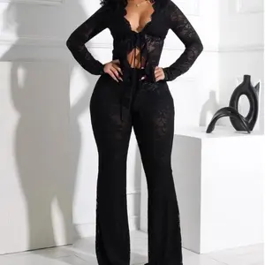 Sexy sheer lace long-sleeve cutout top paired with high-waisted flared lace pants; street-style nightclub wear, rave outfit. Smooth, minimalist fashion; can be worn with a raincoat.