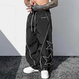 Men’s star print wide-leg athletic pants made from lightweight, breathable nylon fabric, featuring an elastic drawstring waist and contrasting piping; a versatile choice for Y2K street style, skateboarding, everyday wear, and summer outfits.