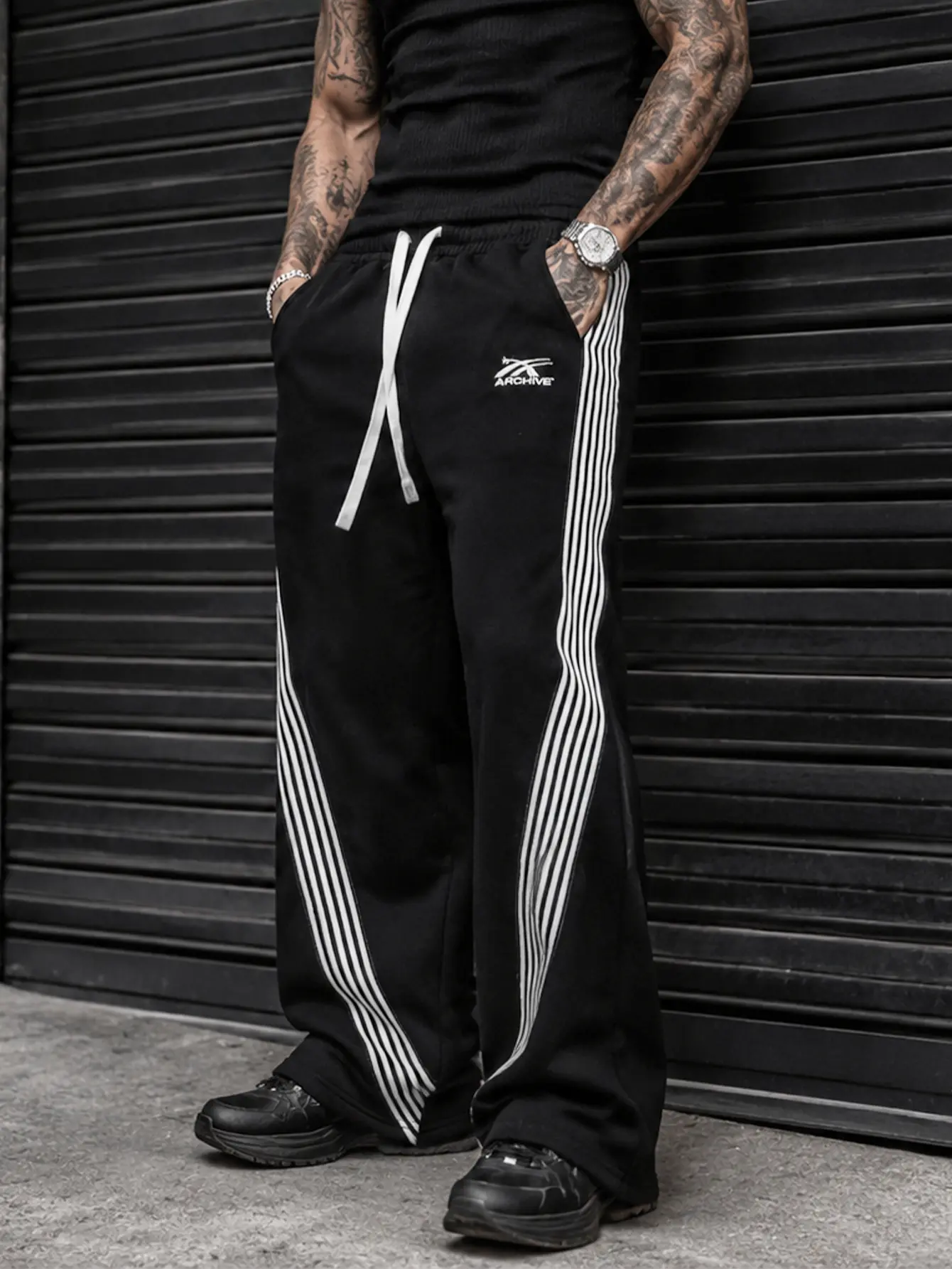 Men’s trendy American-style athletic sweatpants for autumn/winter, featuring multiple white stripes along the side seams and a slight flared leg; elastic waistband with drawstring and small embroidery; wide-leg long pants with a high-street retro drape an