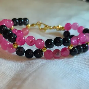 Twisted pink and black beads with golds small bead bracelet