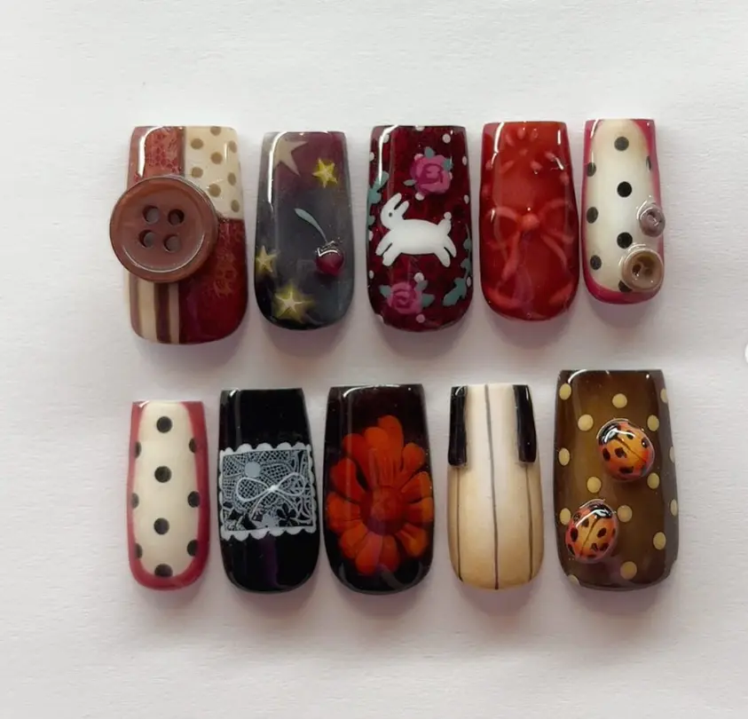 Vintage-inspired nail art with polka dots, lace, florals, stars, rabbits, ladybugs, and 3D buttons, blending retro charm with whimsical details