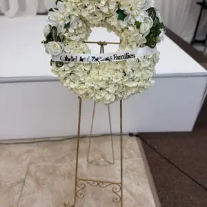 Funeral Wreath with White Flowers and "Families" Banner on Stand