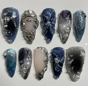 Elegant celestial nail art set in deep navy and silver tones, adorned with pearls, metallic crosses, sculpted flowers, and shimmering cosmic textures