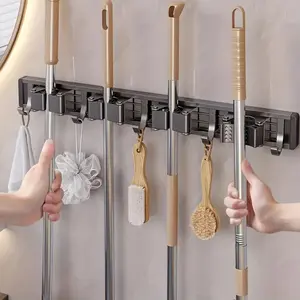 A heavy-duty metal mop and broom holder with detachable hooks, wall-mounted storage rack, suitable for homes, kitchens, gardens, laundry rooms and garages — spray-painted finish, space-saving organizer