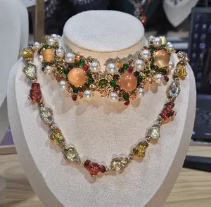 Jody(7791)gc.Step into timeless glamour with this stunning statement necklace.  Rich with vintage-inspired orange opal accents, shimmering crystals, and lustrous pearls, it’s a burst of warm, autumnal hues.