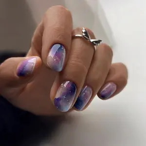 Ethereal Galaxy Nail Art – A mesmerizing manicure that blends shades of violet, lavender, and midnight blue in a dreamy cosmic gradient, accented with tiny white starbursts to create the illusion of a twinkling night sky.