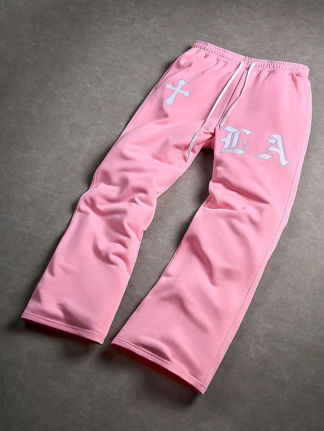 Unisex pink gothic cross LA embroidery flare sweatpants — elastic drawstring waist, side pockets, 3D appliqué details, drapey knit fabric; Y2K sweet and edgy high street pants for skating, street snaps, and couple looks