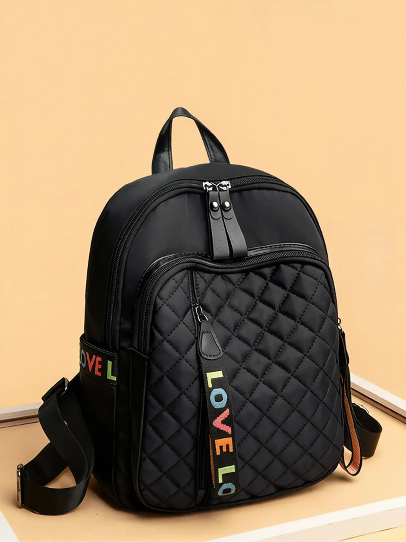Black diamond grid quilted backpack with colorful letter ribbon decoration, adjustable shoulder strap design for women's casual backpack