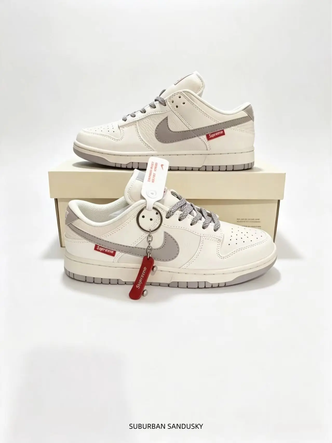 These cream low-top sneakers with grey swoosh and red buckle details deliver trendy street aesthetics and all-day comfort for casual daily outfits.
