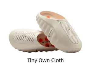 Minimal creamy off-white molded slide sandals with tiny orange traction nubs for summer casual fits