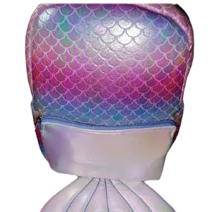 Mermaid Backpack. This eye-catching backpack is pink, blue, and white with an iridescent sheen, covered in scale designs, and has a mermaid tail dangling from the bottom of it