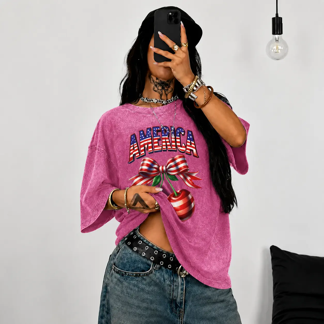 A women's vintage-style acid-wash T-shirt featuring a graphic print of the American flag, a bow, and cherries. Made from soft, comfortable fabric with a unisex streetwear vibe, it is perfect for campus wear, parties, and outdoor activities.
