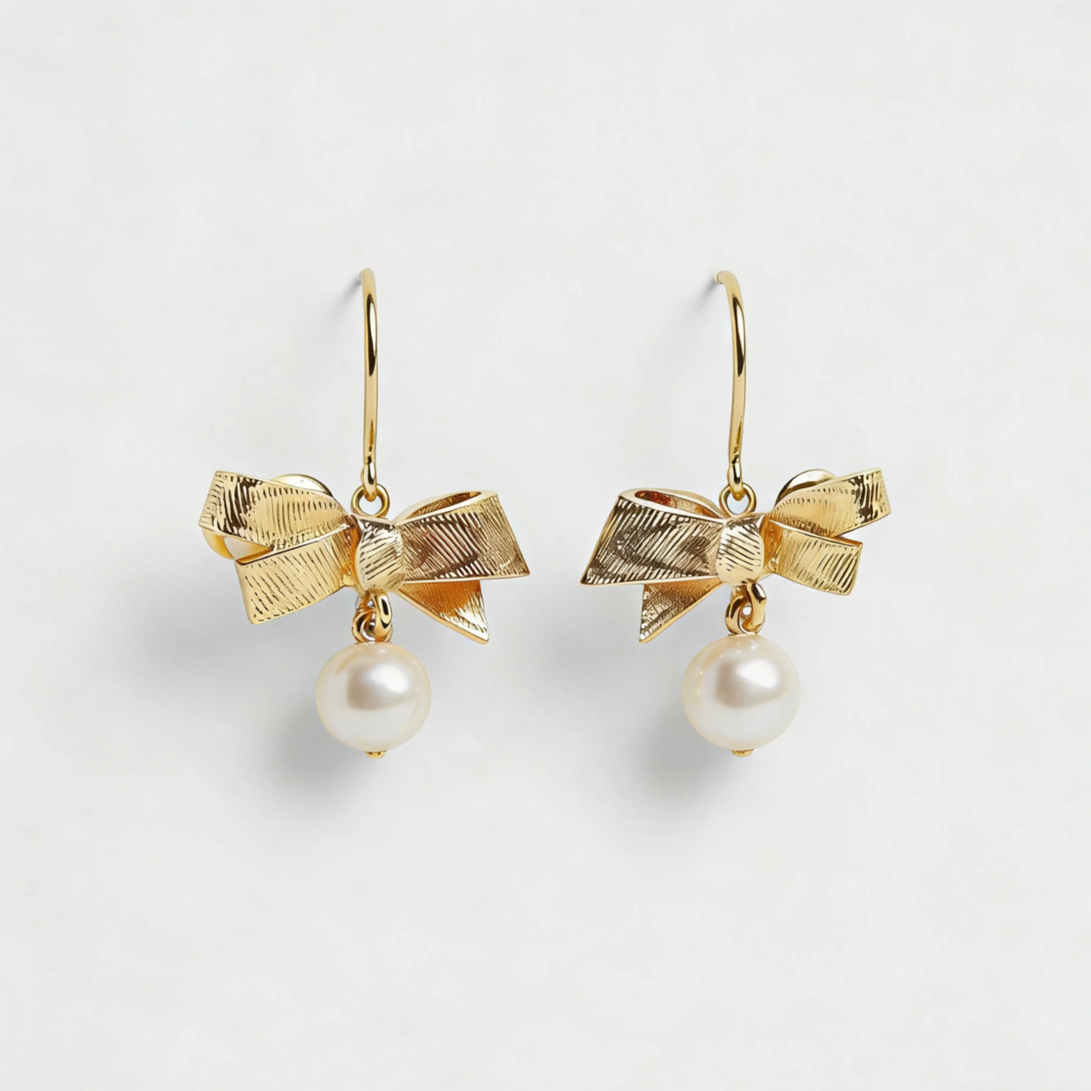 Gold textured bow-shaped pearl stud earring