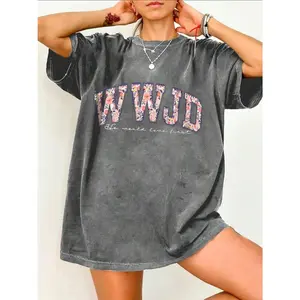 Women's 100% Washed Religious Theme 'WWJD - He Will Love First' Printed T-Shirt: Features a Distressed Vintage Finish, Adorned with Floral 'WWJD' (What Will Jesus Do?) Lettering Print, and Delicate Handwritten 'He Will Love First' Lettering. M