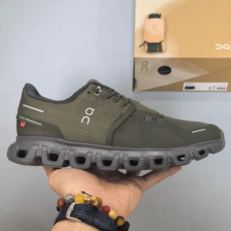 Retro running sneakers with flexible segmented shock-absorbing athletic silhouette, premium breathable knit mesh finished in matte olive green paired with slim silver reflective strip accents, hollow dark gray foam midsole