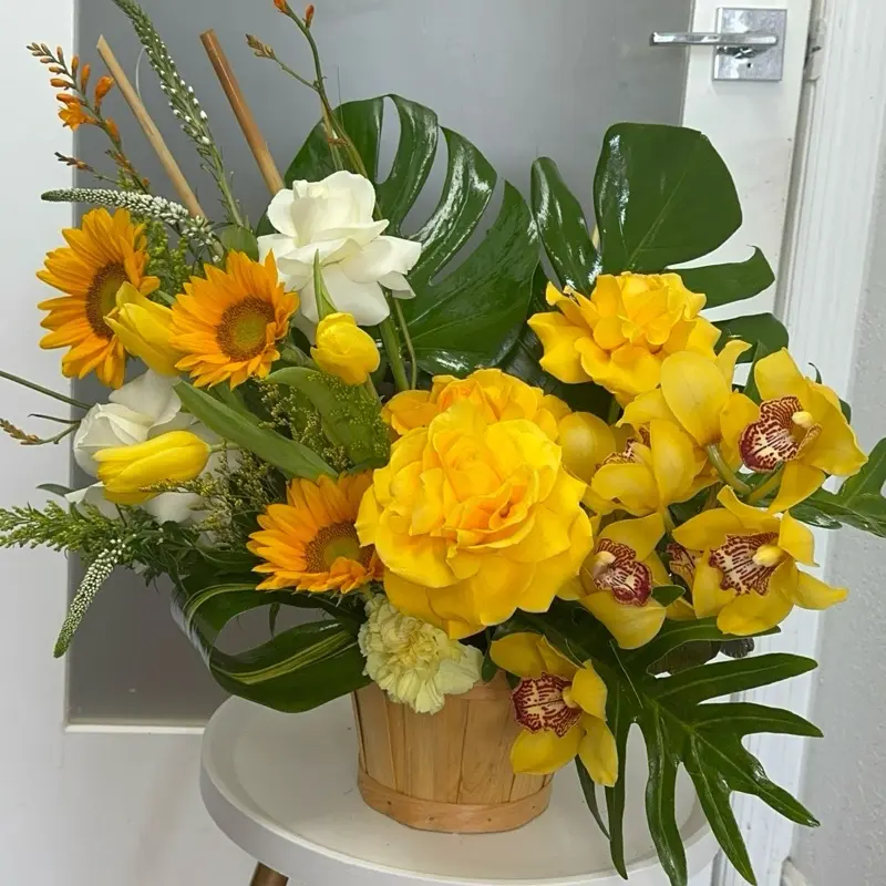 Yellow Universe Bouquet with Sunflowers, Orchids, and Monstera Leaves in Wooden Basket