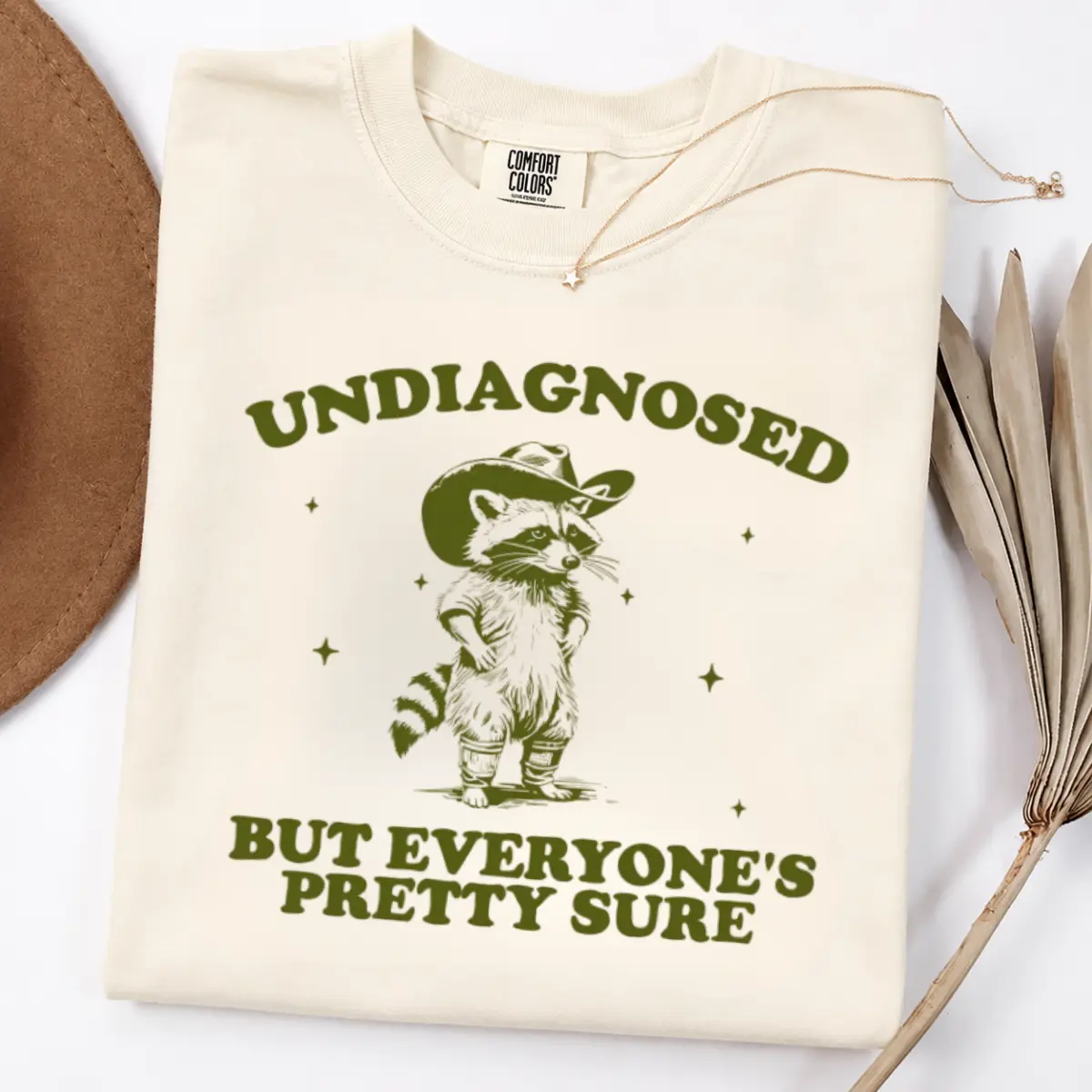 [Sale Up To 55%] Comfort Colors Undiagnosed Raccoon Shirt, Funny Cowboy Raccoon Graphic Tee, Sarcastic Animal T-Shirt, Vintage Western Style, Quirky Casual Vibe - Leo Prime