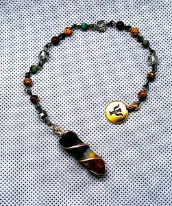 Chakra pendulum with seven semi-precious stones with a chain of stones and crystals ending with a Psi pendant