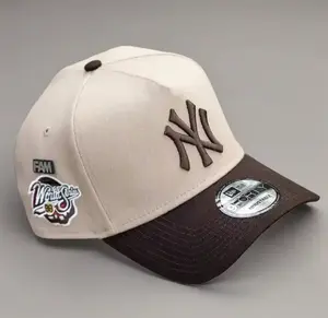 9FORTY New York World Series Side Patch Baseball Cap – Cream & Brown, Adjustable Size, Brown NY Logo.
