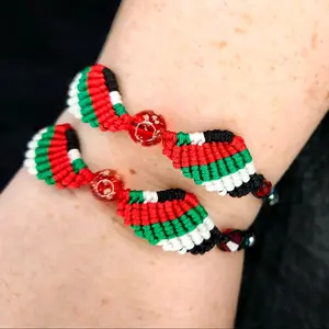 Free Palestine Solidarity Macrame Angel Wing Bracelet with Glow in the Dark Glass Lamp Work Bead in the center. made in the colors of the Palestinian flag
