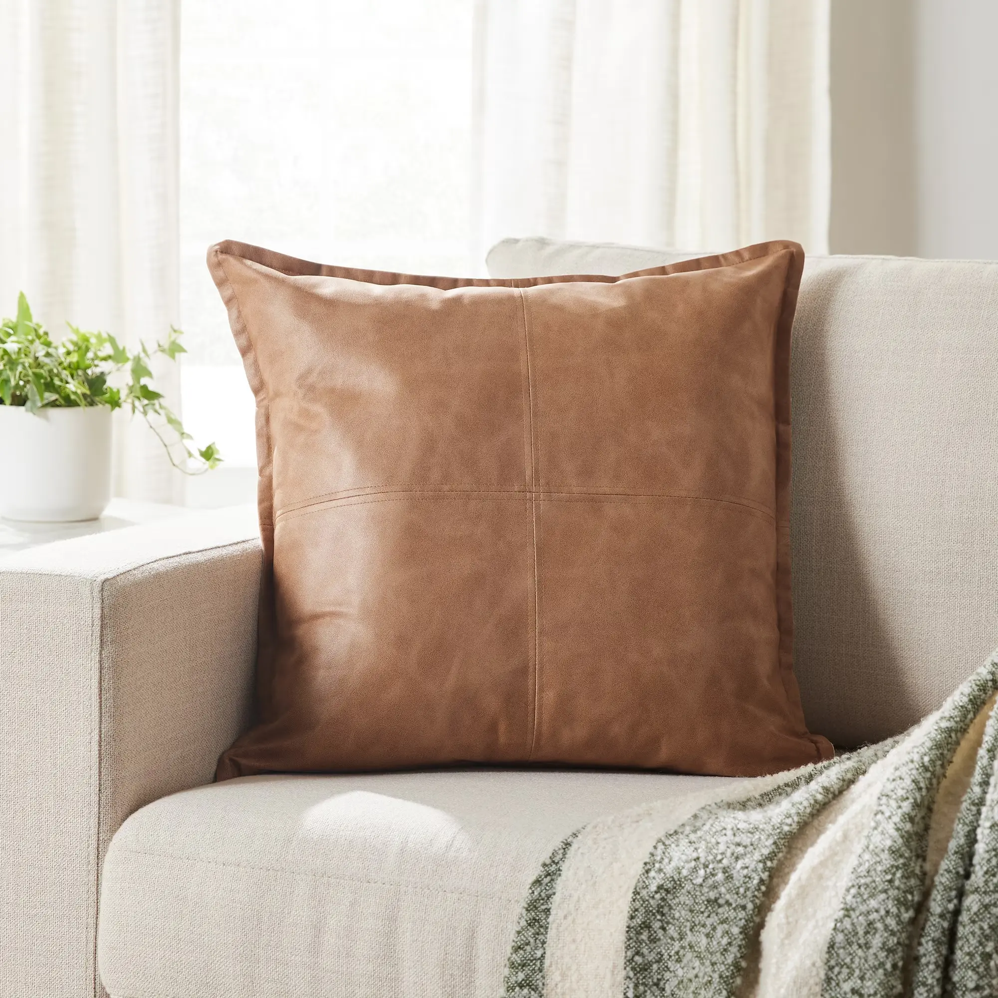 Beige faux leather decorative pillow.