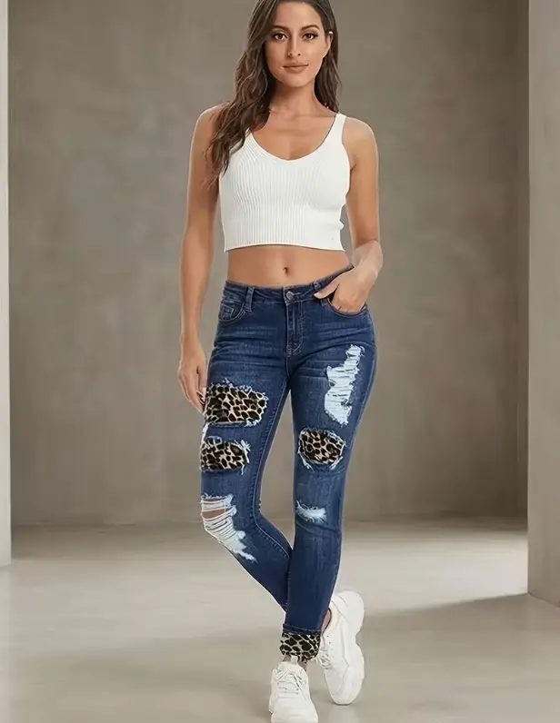Women's Mid-rise Skinny Jeans with leopard print patch and ripped details. Dark wash stretch fabric to accentuate your curves, featuring a trendy street and casual style