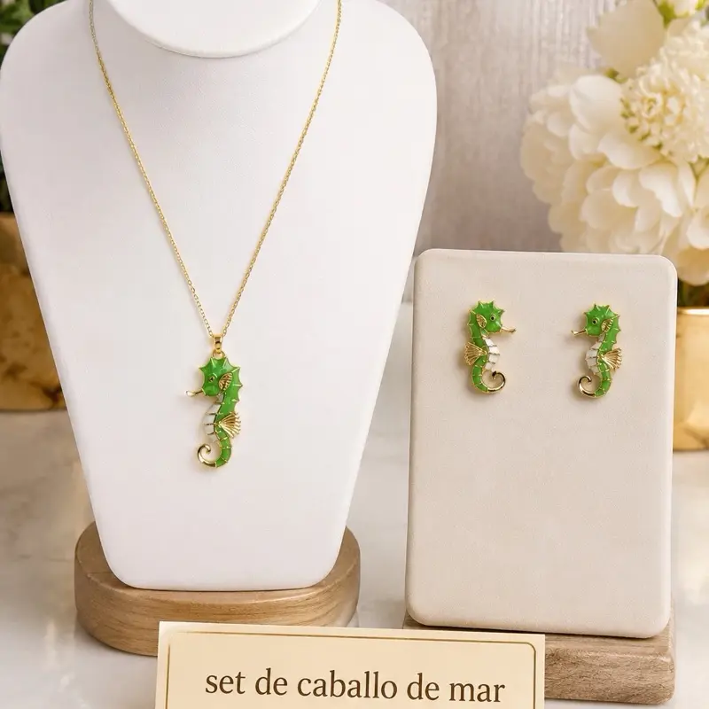 Set caballito de mar . Inspirado en la belleza del océano, este hermoso set incluye una delicada cadena con dije de caballito de mar y aretes a juego en un elegante tono verde y detalles dorados. Chapado en oro laminado 14 k