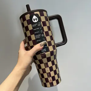 This "Hydrojug" checkered insulated cup features a brown and yellow check pattern. It is a double-layered stainless steel flip-top insulated cup with a capacity of 40 ounces and is made of high-quality stainless steel.