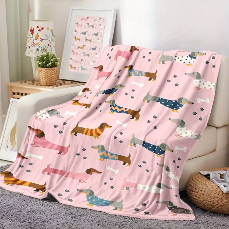A black and tan dachshund illustration on a cream pillow rests on a red A black and tan dachshund illustration on a cream pillow rests on a red