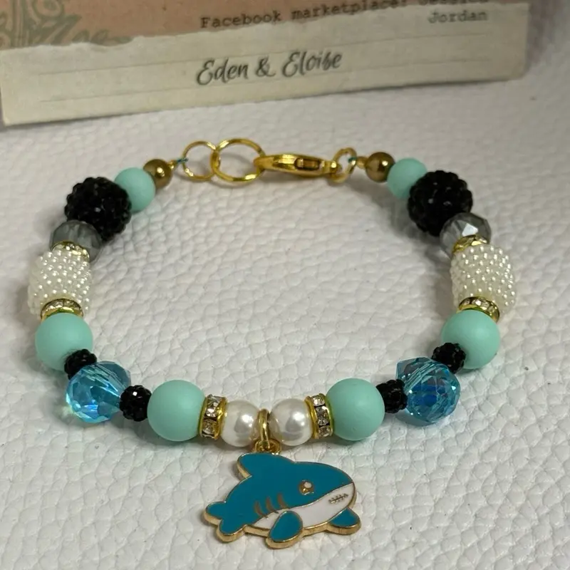 Handmade blue shark charm and blue and black and white bead bracelet