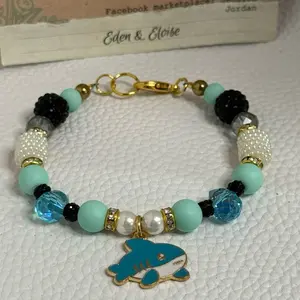 Handmade blue shark charm and blue and black and white bead bracelet