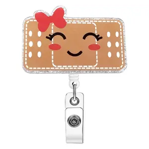 A work card telescopic buckle with cartoon Band-Aid shape, the Band-Aid is brown, with white stitches, polka dot decoration, equipped with telescopic structure and metal clip, can be used to hang work cards, suitable for medical scenarios