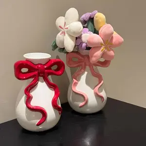 An imaginative bow-shaped resin vase - Decorative Flower Vase, romantic wedding and home decor item, featuring elegant pink and white flower designs. It is the ideal gift for brides, girlfriends, birthdays or graduation ceremonies.