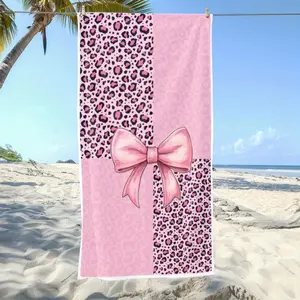 A Microfibre Beach Towel Featuring a Pink Leopard Print Design, Complete with a Large Bow. It'S Fashionable, Absorbent, And Perfect for Summer, Made from Quick-Drying Polyester