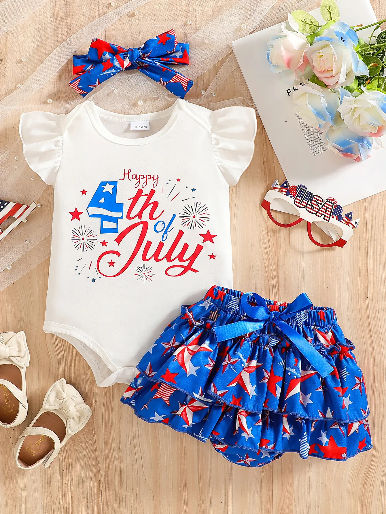 Baby girl summer set white ruffled short sleeved bag fart jacket "Happy 4th of July" holiday element print paired with red and blue star multi-layer ruffled shorts and butterfly bow hair accessories, cute American Independence Day outfit